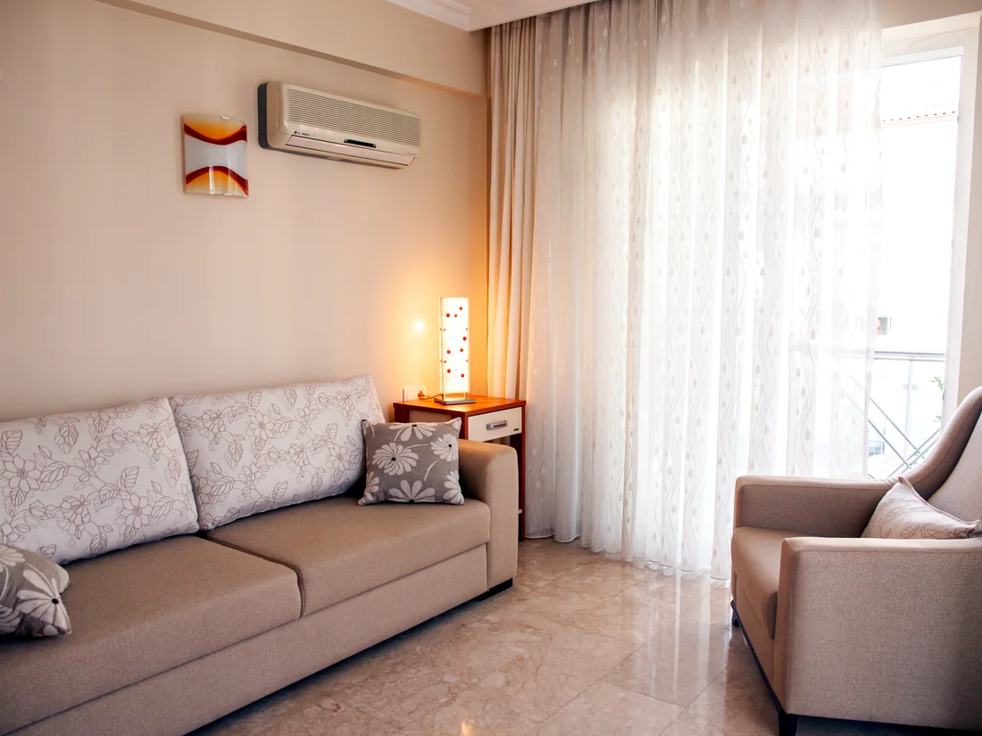 Sofa-bed room with armchair and balcony doors at Calis Sunstay